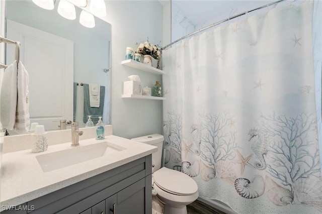 bathroom featuring vanity, toilet, and curtained shower