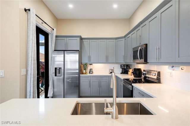 kitchen with sink, appliances with stainless steel finishes, and tasteful backsplash