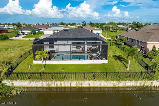 back of property featuring glass enclosure, a fenced in pool, a yard, and a water view