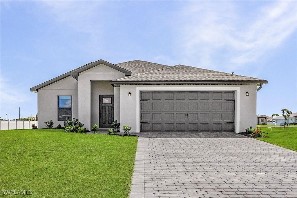 1313 Bush St W, Immokalee, FL 34142 - view of front of home featuring decorative driveway, an attached garage, stucco siding, and a shingled roof