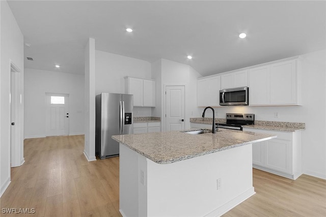 1313 Bush St W, Immokalee, FL 34142 - kitchen featuring appliances with stainless steel finishes, a sink, light wood-style floors, white cabinets, and an island with sink