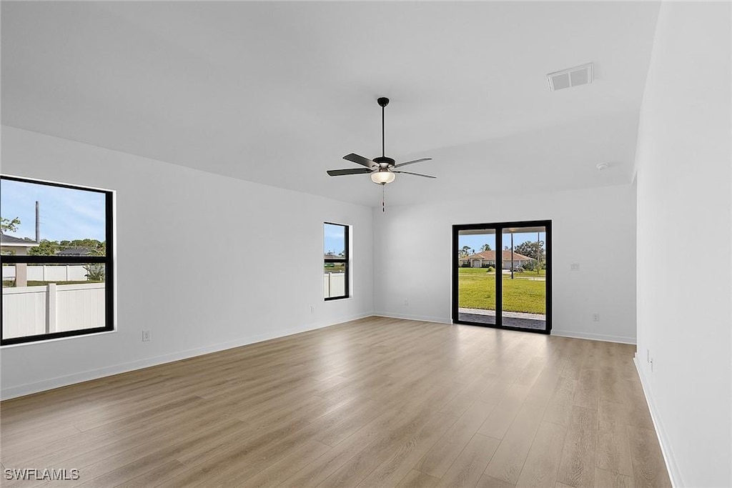 1313 Bush St W, Immokalee, FL 34142 - spare room featuring plenty of natural light, light wood-type flooring, a ceiling fan, and baseboards