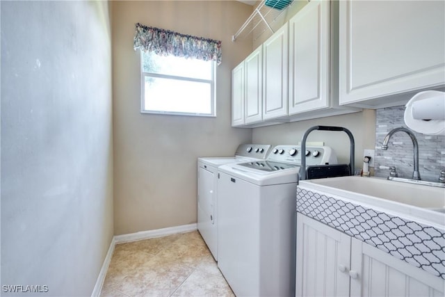 clothes washing area with cabinets, light tile patterned floors, washer and clothes dryer, and sink