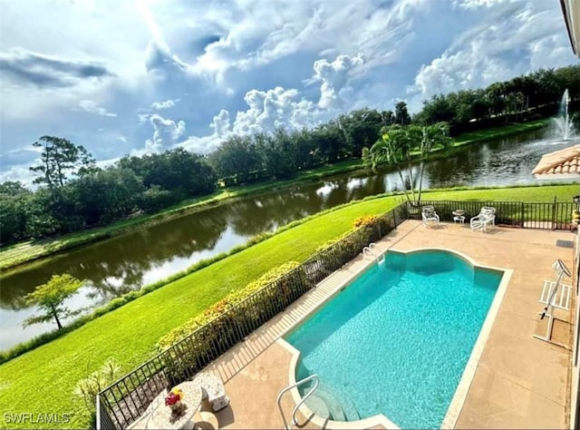 view of swimming pool featuring a water view, a patio area, and a lawn