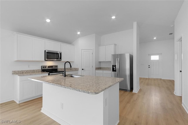 1310 Bush St W, Immokalee, FL 34142 - kitchen with stainless steel appliances, a sink, a center island with sink, white cabinets, and light wood-type flooring