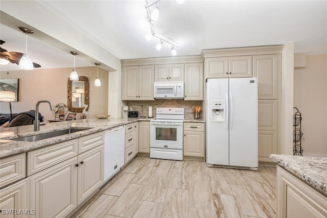 kitchen featuring sink, cream cabinets, white appliances, and tasteful backsplash