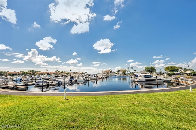 view of dock with a yard and a water view