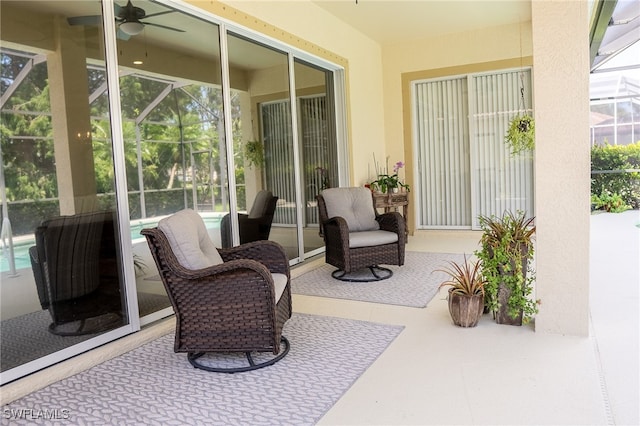 view of patio / terrace featuring ceiling fan and a lanai