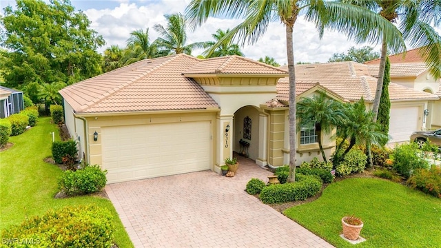 mediterranean / spanish home with decorative driveway, a tile roof, stucco siding, an attached garage, and a front yard