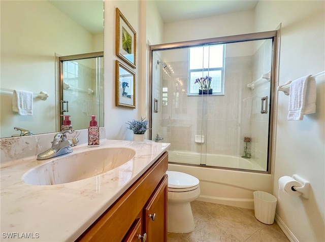 full bathroom featuring tile patterned flooring, vanity, toilet, and bath / shower combo with glass door