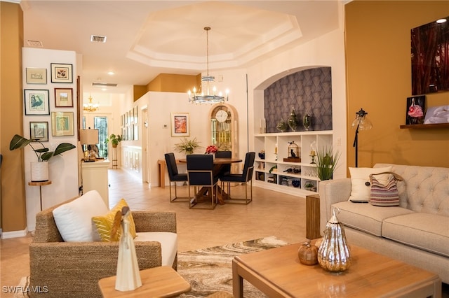 living room featuring light tile patterned floors, a tray ceiling, and an inviting chandelier