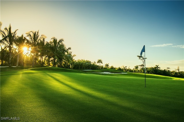 view of property's community with view of golf course and a yard