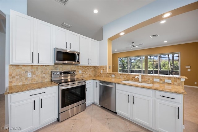 kitchen with visible vents, appliances with stainless steel finishes, a peninsula, white cabinetry, and a sink