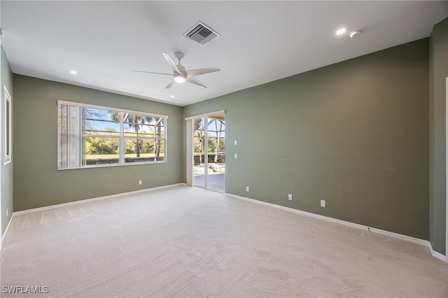 empty room with visible vents, light carpet, and baseboards