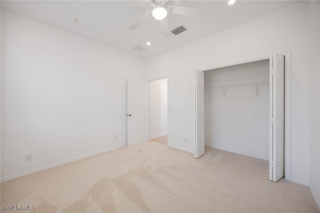 unfurnished bedroom with baseboards, visible vents, a closet, and light colored carpet