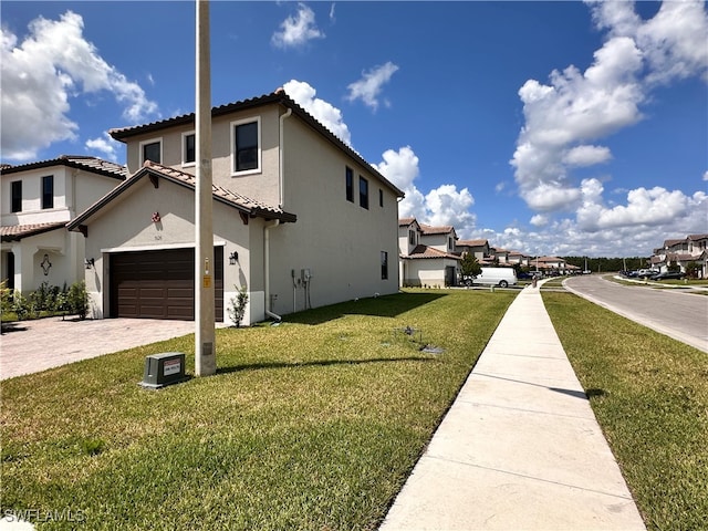 view of side of property with a yard and a garage