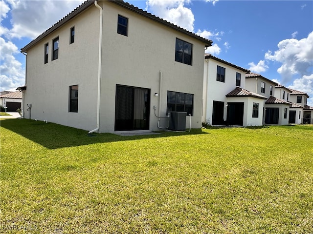 back of house with central AC unit and a lawn