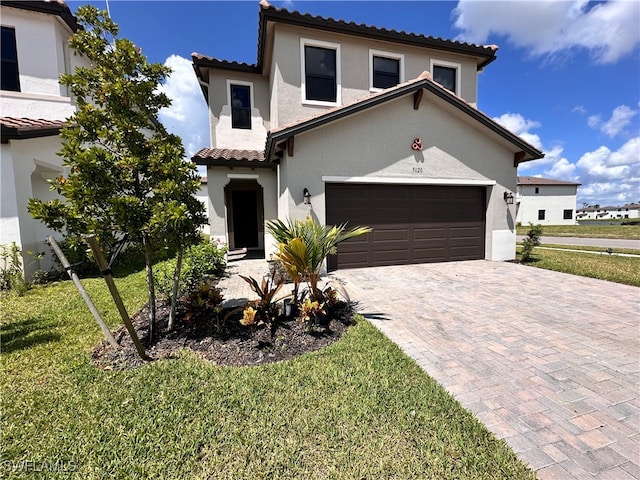 mediterranean / spanish house with a garage and a front lawn