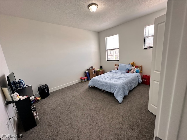 bedroom featuring a textured ceiling and dark carpet