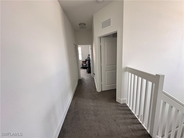 hall with dark colored carpet