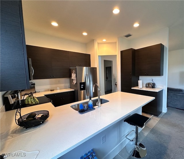 kitchen featuring kitchen peninsula, a kitchen bar, stainless steel appliances, and sink