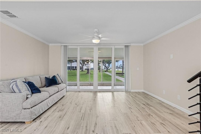 living area with baseboards, crown molding, and wood finished floors