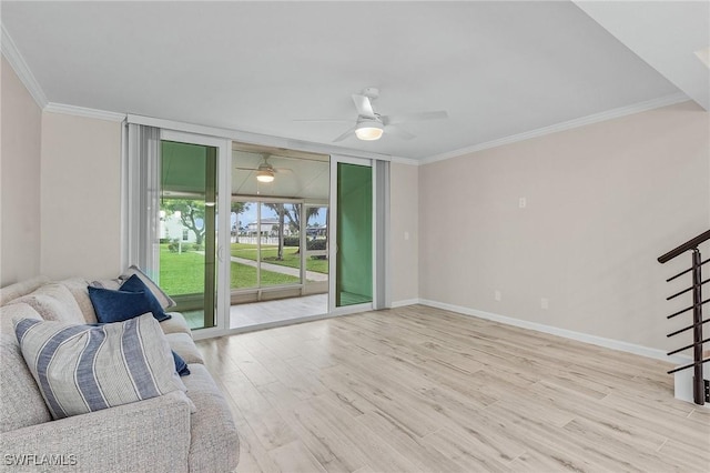 unfurnished living room featuring crown molding, stairway, wood finished floors, a wall of windows, and baseboards