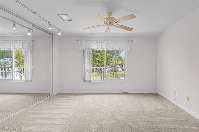 empty room with carpet, visible vents, ceiling fan, and baseboards