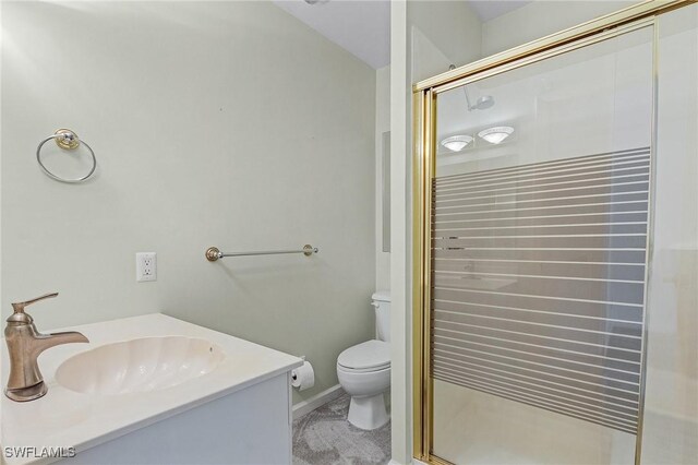 full bathroom featuring a stall shower, vanity, and toilet