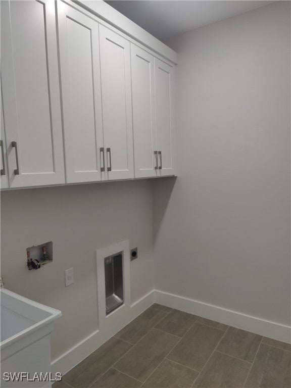 clothes washing area with cabinets, hookup for an electric dryer, and hookup for a washing machine