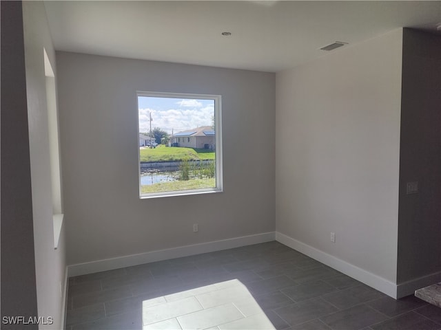 tiled empty room featuring a water view