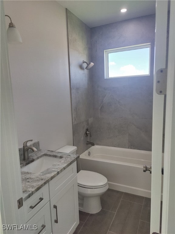 full bathroom with tiled shower / bath combo, vanity, toilet, and tile patterned floors