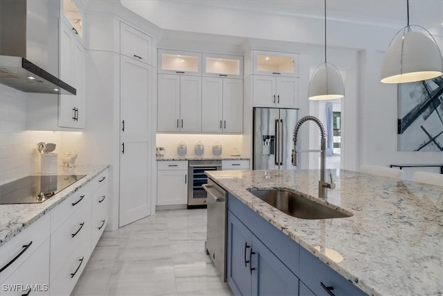 kitchen featuring beverage cooler, stainless steel appliances, a sink, white cabinets, and wall chimney range hood