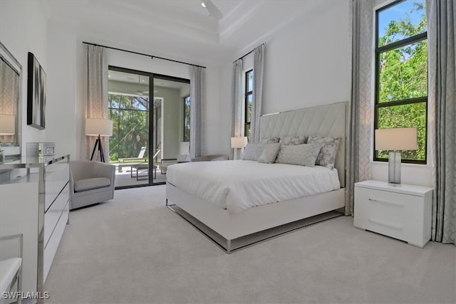 bedroom featuring access to exterior, light carpet, and multiple windows