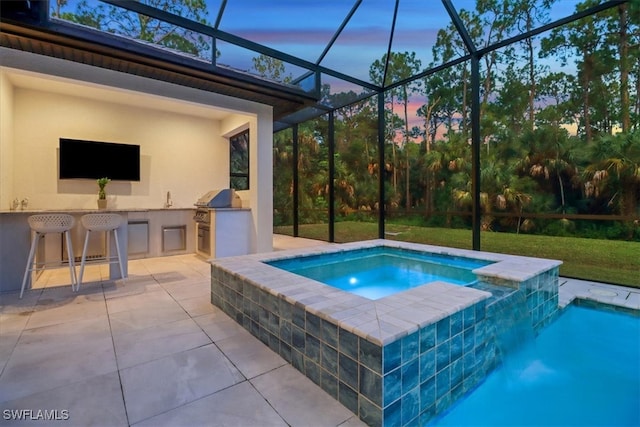 view of pool with an outdoor kitchen, a lanai, a grill, outdoor wet bar, and a patio area