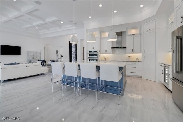 kitchen with backsplash, appliances with stainless steel finishes, white cabinets, coffered ceiling, and wall chimney exhaust hood