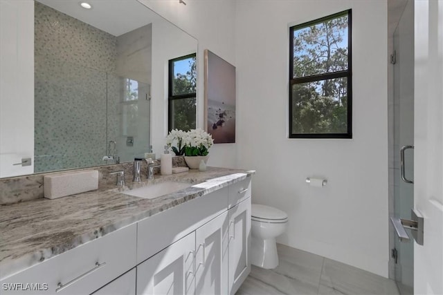 full bath featuring toilet, a stall shower, and vanity