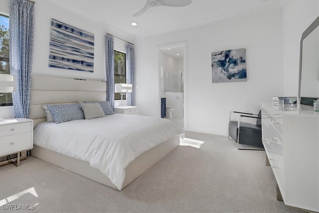 bedroom with ensuite bathroom, multiple windows, recessed lighting, and light colored carpet