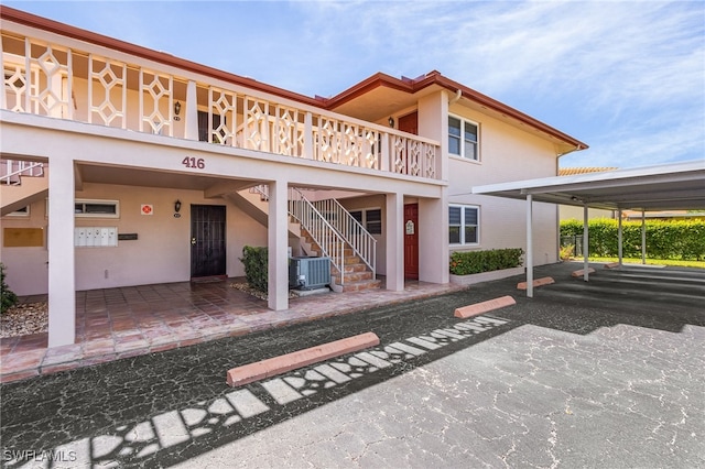 rear view of house with a carport and cooling unit