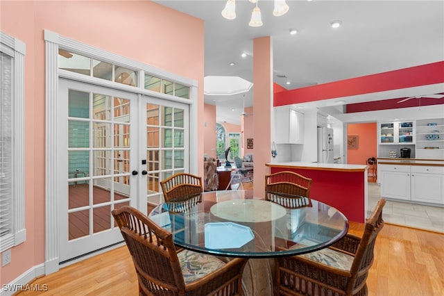 dining room with french doors and light hardwood / wood-style flooring