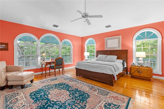 bedroom featuring multiple windows, ceiling fan, and hardwood / wood-style flooring