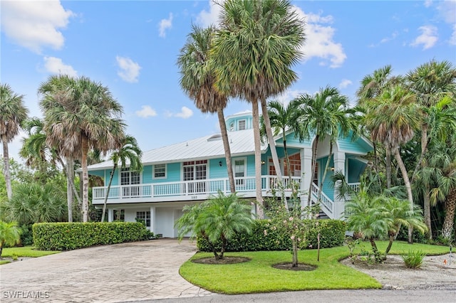 beach home featuring a front lawn