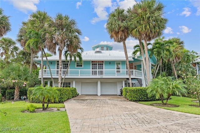 coastal home with a garage and a front yard