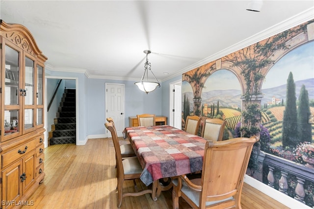 dining space featuring ornamental molding and light hardwood / wood-style flooring