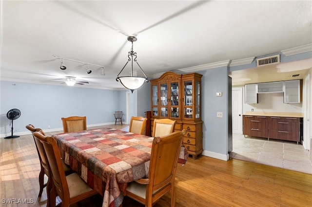 dining area with ceiling fan, ornamental molding, light wood-type flooring, and track lighting