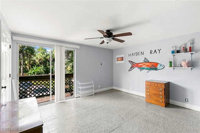 unfurnished room with baseboards, a ceiling fan, and speckled floor