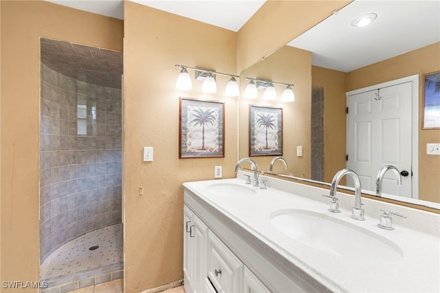 bathroom with a tile shower and vanity