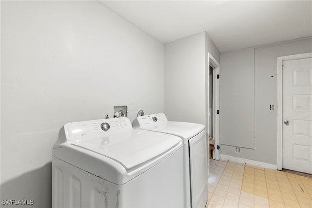 laundry area with separate washer and dryer and light tile patterned flooring