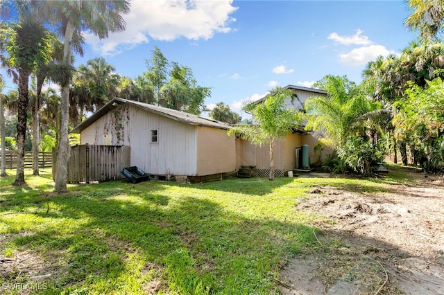 view of property exterior with fence and a yard