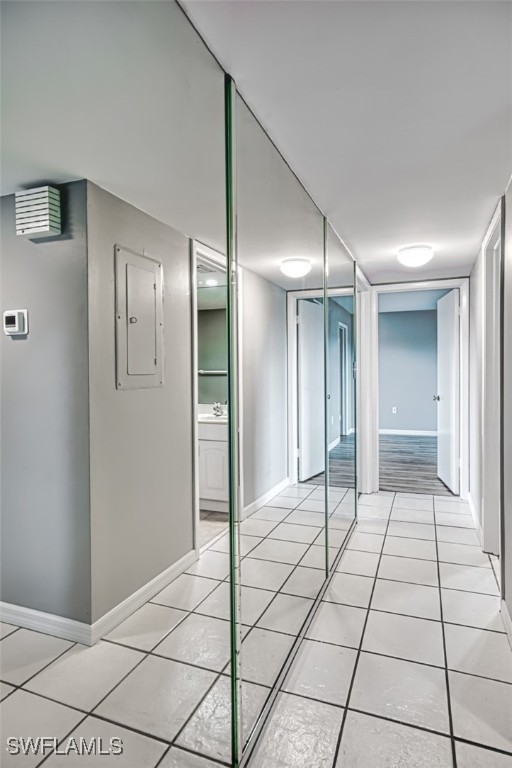 interior space with light tile patterned floors, electric panel, and sink